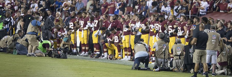 Some players for the Washington Redskins kneel for the National Anthem.