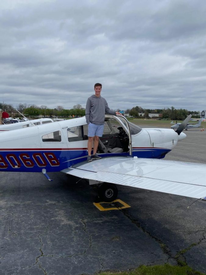 Senior Will Mensh standing atop an airplane, which he has been able to fly since his 16th birthday.