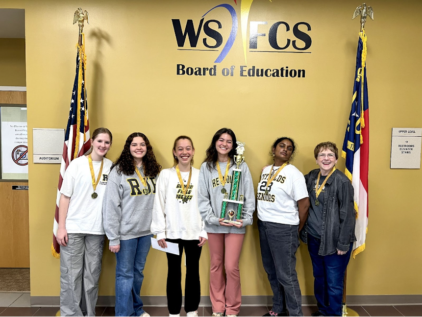 The Battle of the Books Team celebrates their district win with big smiles and a memorable trophy.
